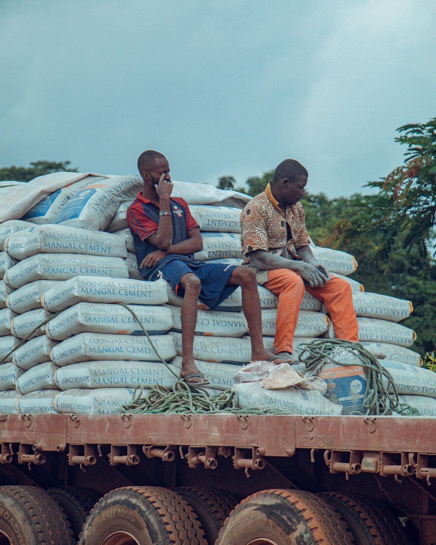 Two shippers sitting on a load of bagged cement